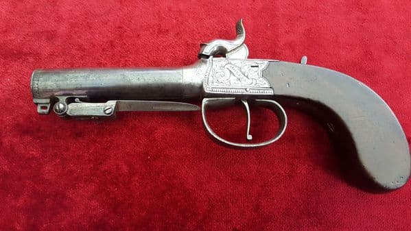 A good English single barrelled percusion pistol with spring bayonet by 